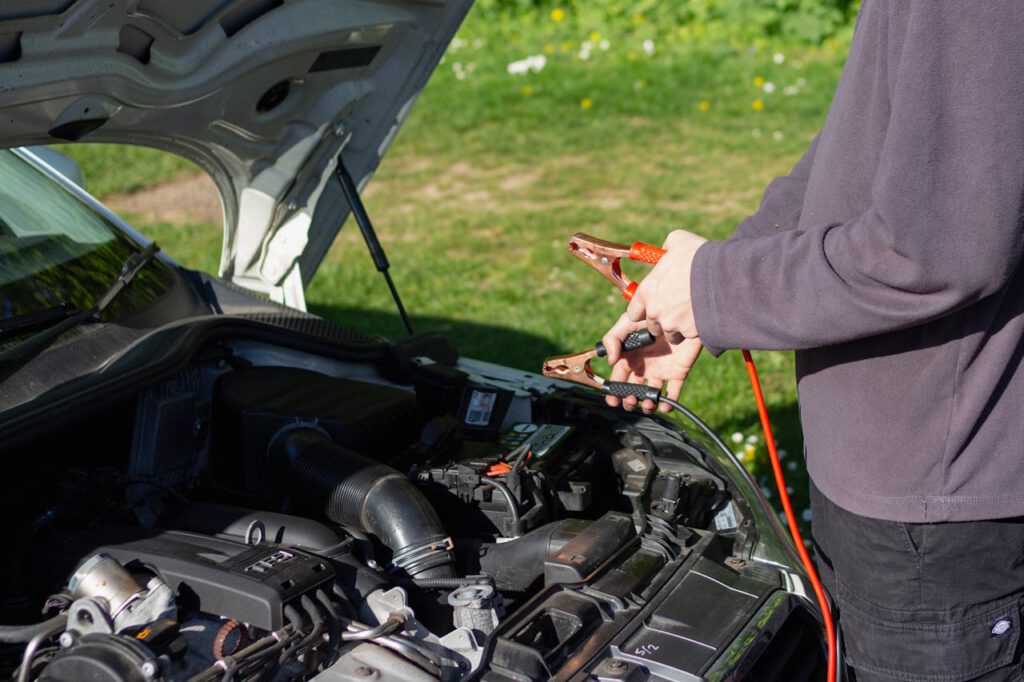 Een accu van een auto opladen met behulp van startkabels